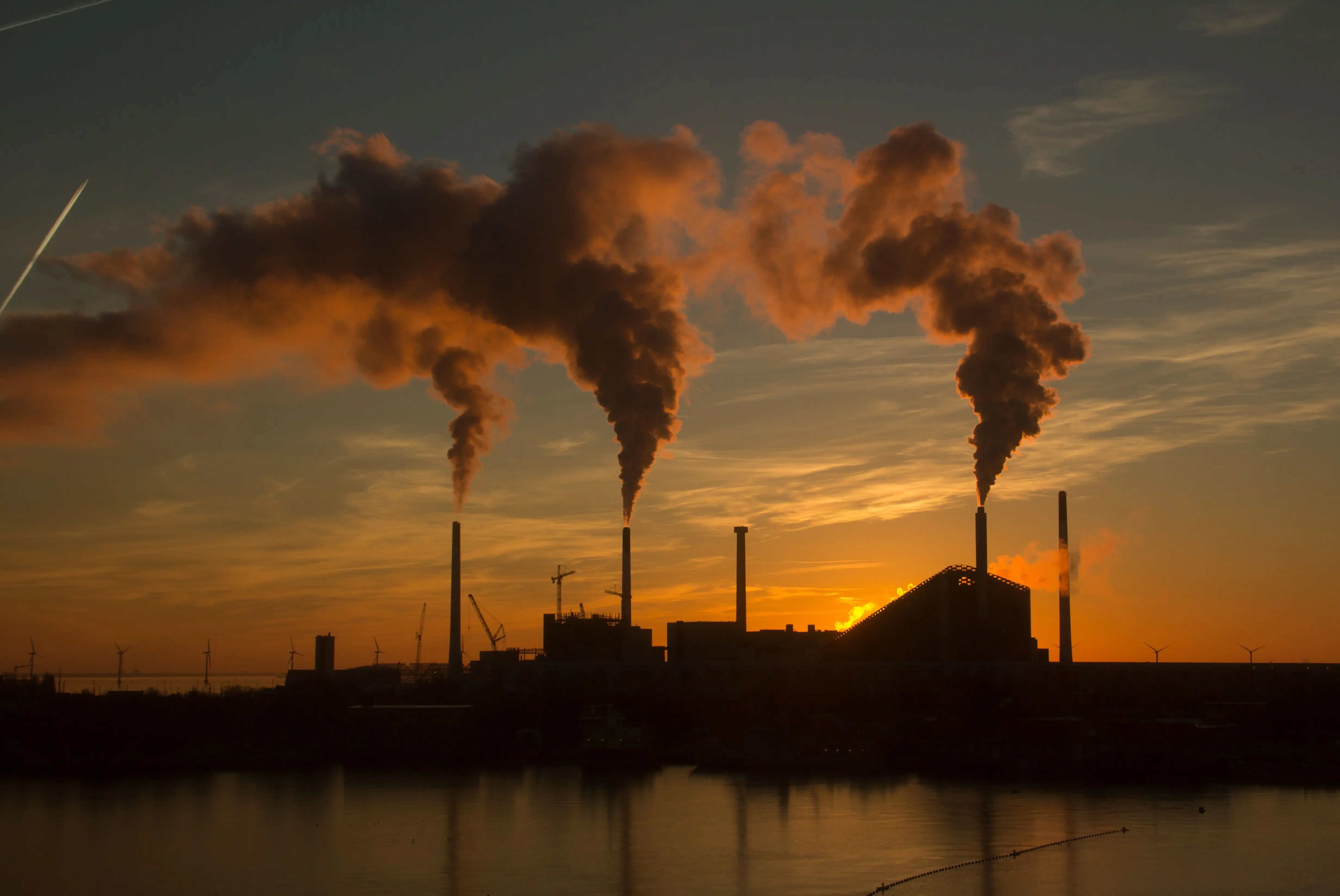 low-angle-shot-factory-with-smoke-steam-coming-out-chimneys-captured-sunset.jpg