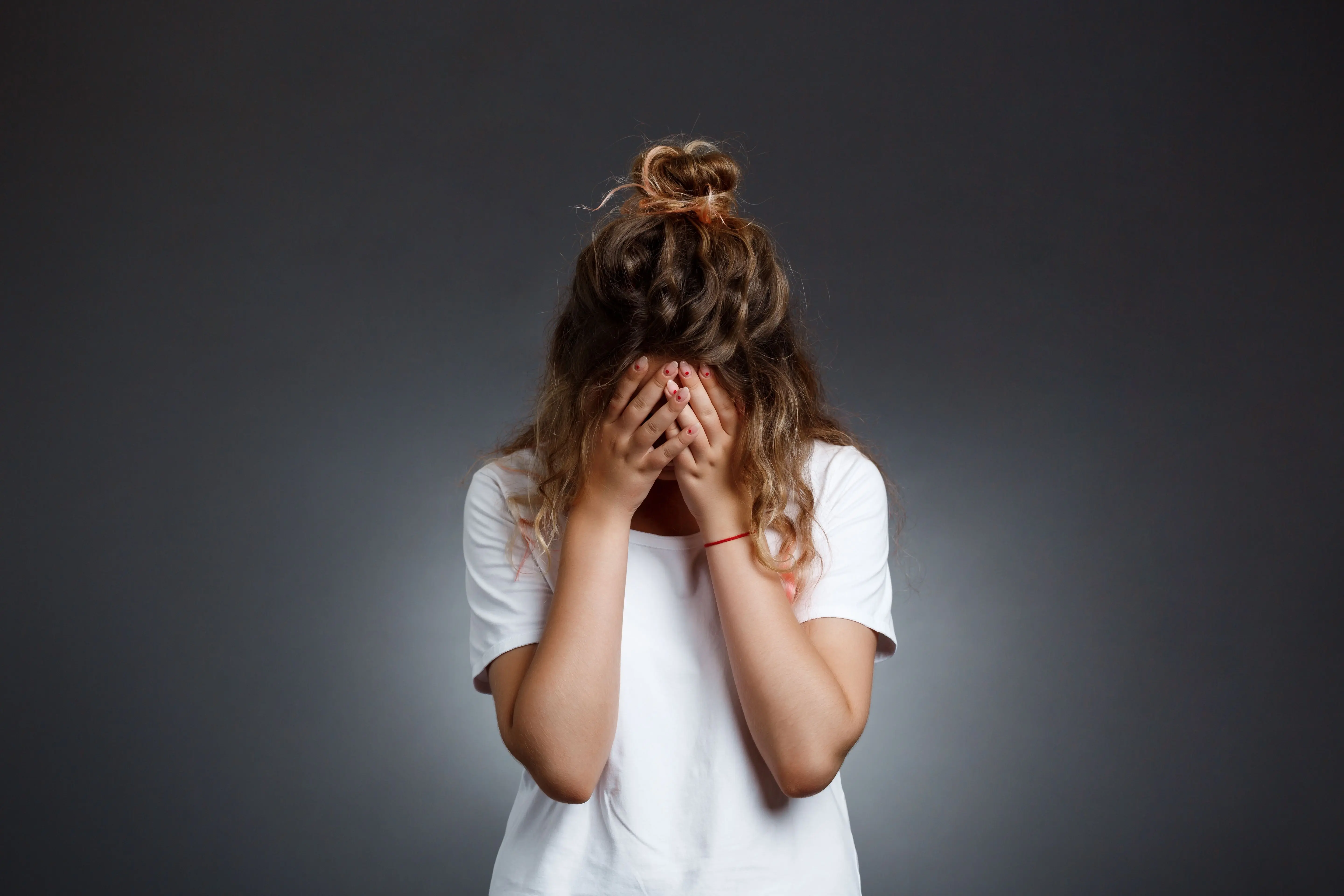 young-beautiful-girl-hiding-face-with-hands-grey-wall.jpg